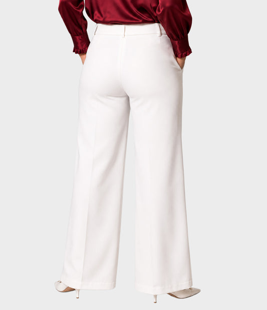 White wide-leg trousers shown from the back on a model wearing a burgundy satin blouse and beige heels, against a light gray studio background.